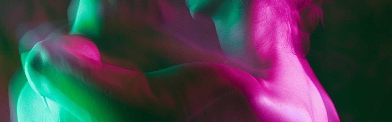 Abstract figures in pink and green light sharing intimate moment, capturing sensations of first-time sex
