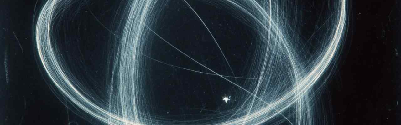 Glowing white loops of light swirling in a mesmerizing motion, creating a sense of cosmic speed and flow.